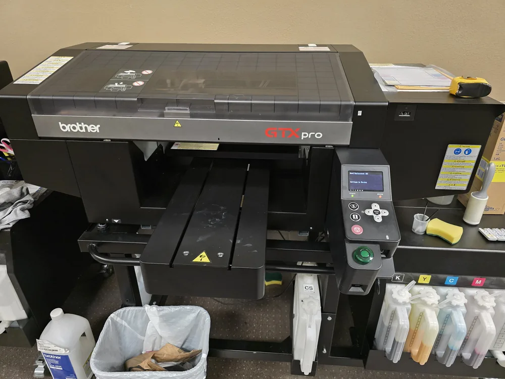 Brother GTX pro direct-to-garment printer with its ink supply