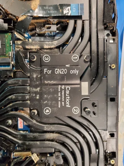 Laptop opened for cleaning, showing dust in the cooling path