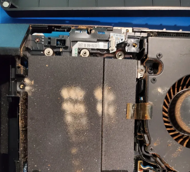 Laptop opened for cleaning, showing dust in the cooling path