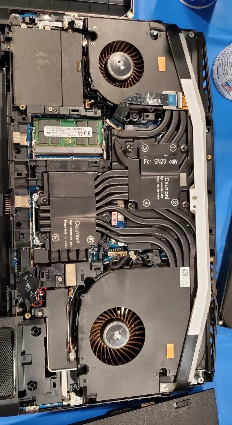 Laptop opened for cleaning, showing dust in the cooling path