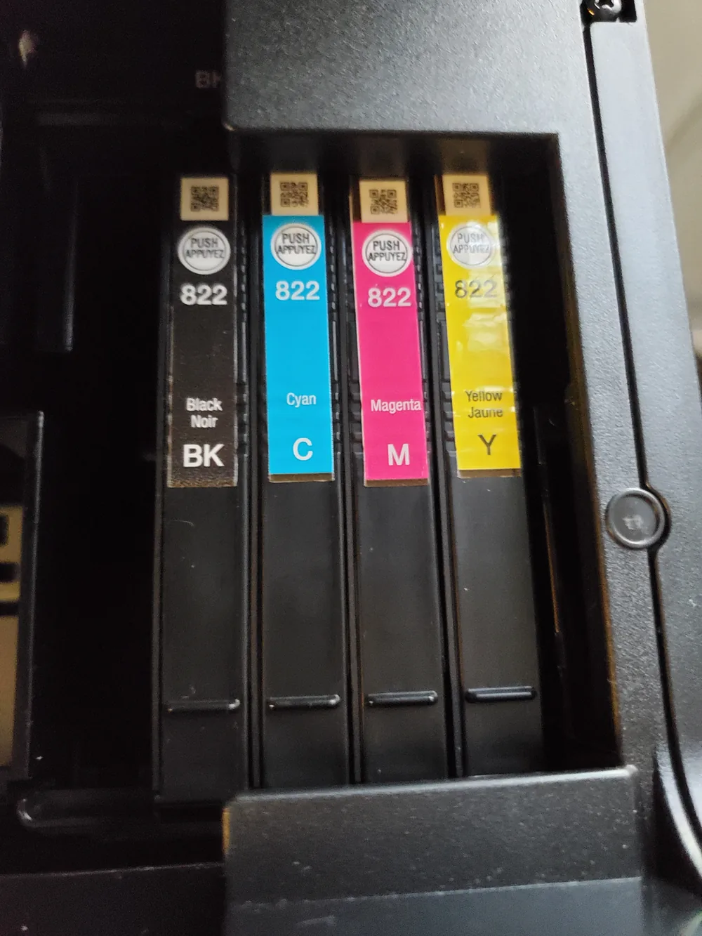 Black, cyan, magenta and yellow ink cartridges installed in a printer